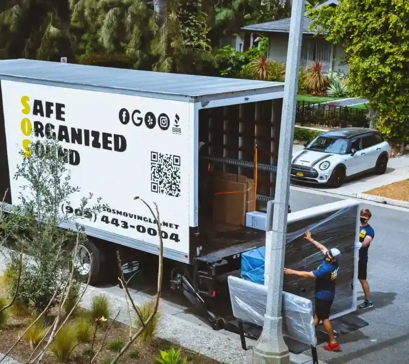 SOS Moving crew carefully loading wrapped furniture into truck